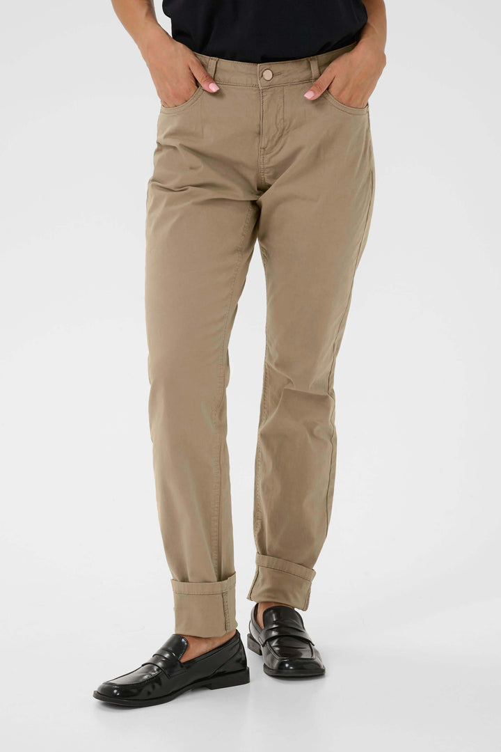 Pantalon Berta beige, coupe droite, revers en bas, style décontracté chic, porté avec chemise noire.