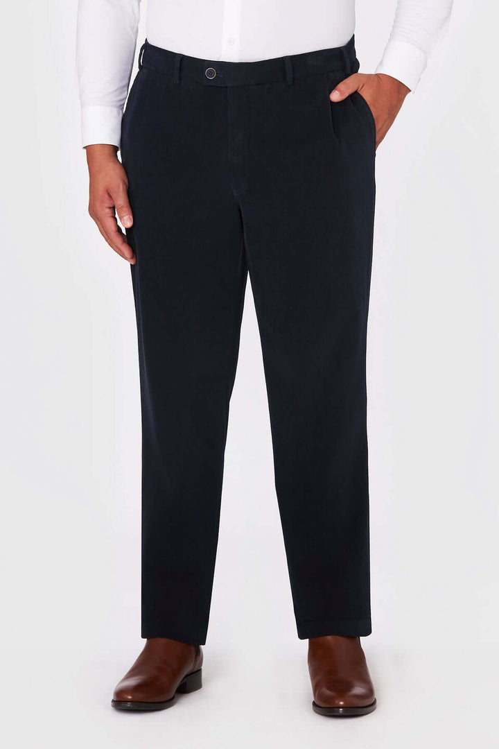 Homme portant un Pantalon Chino Trento noir, élégant et confortable, parfait pour le travail, avec des chaussures marron formelles.