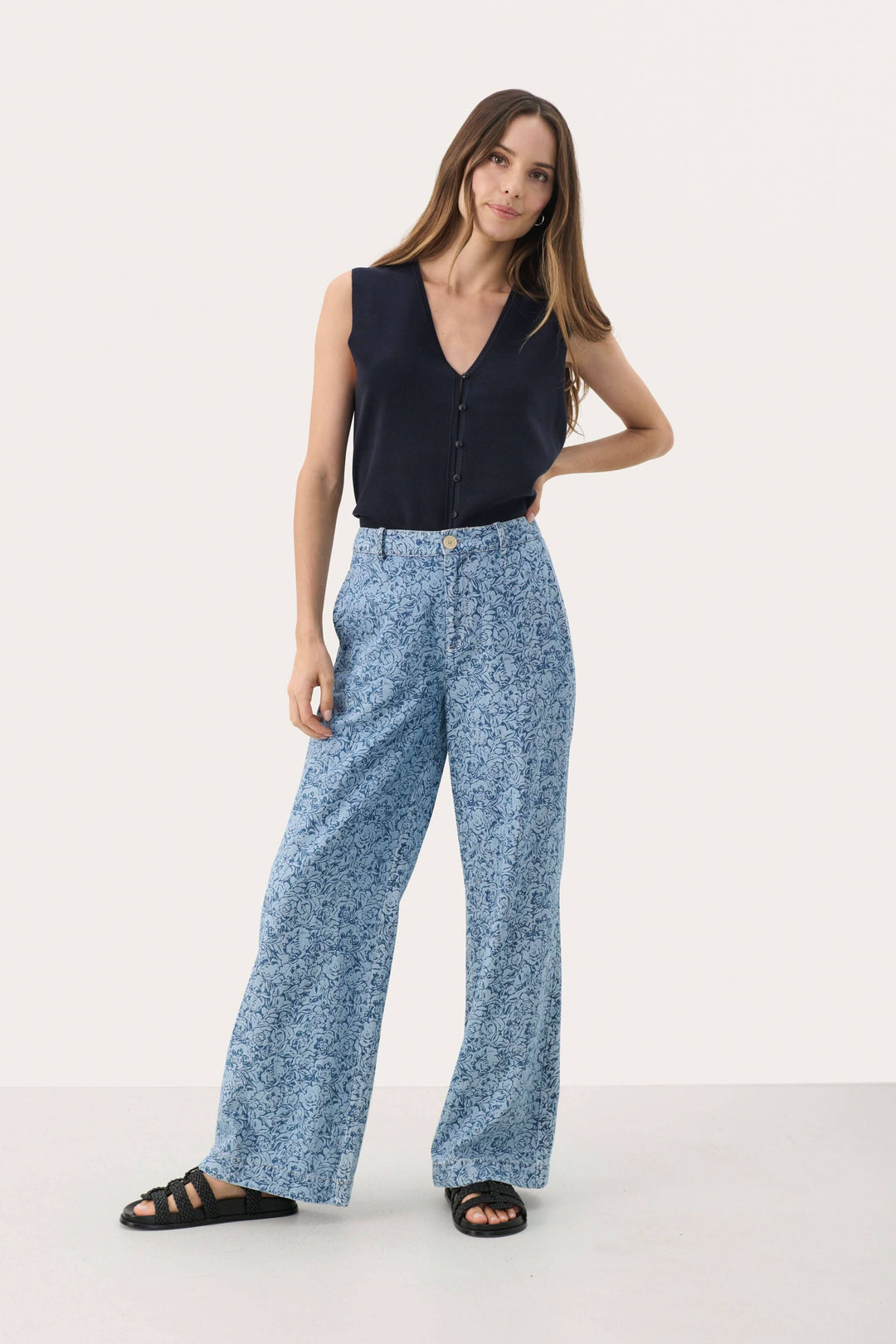Pantalon Coralie à motif floral avec coupe large et taille haute, porté par une modèle en haut noir.