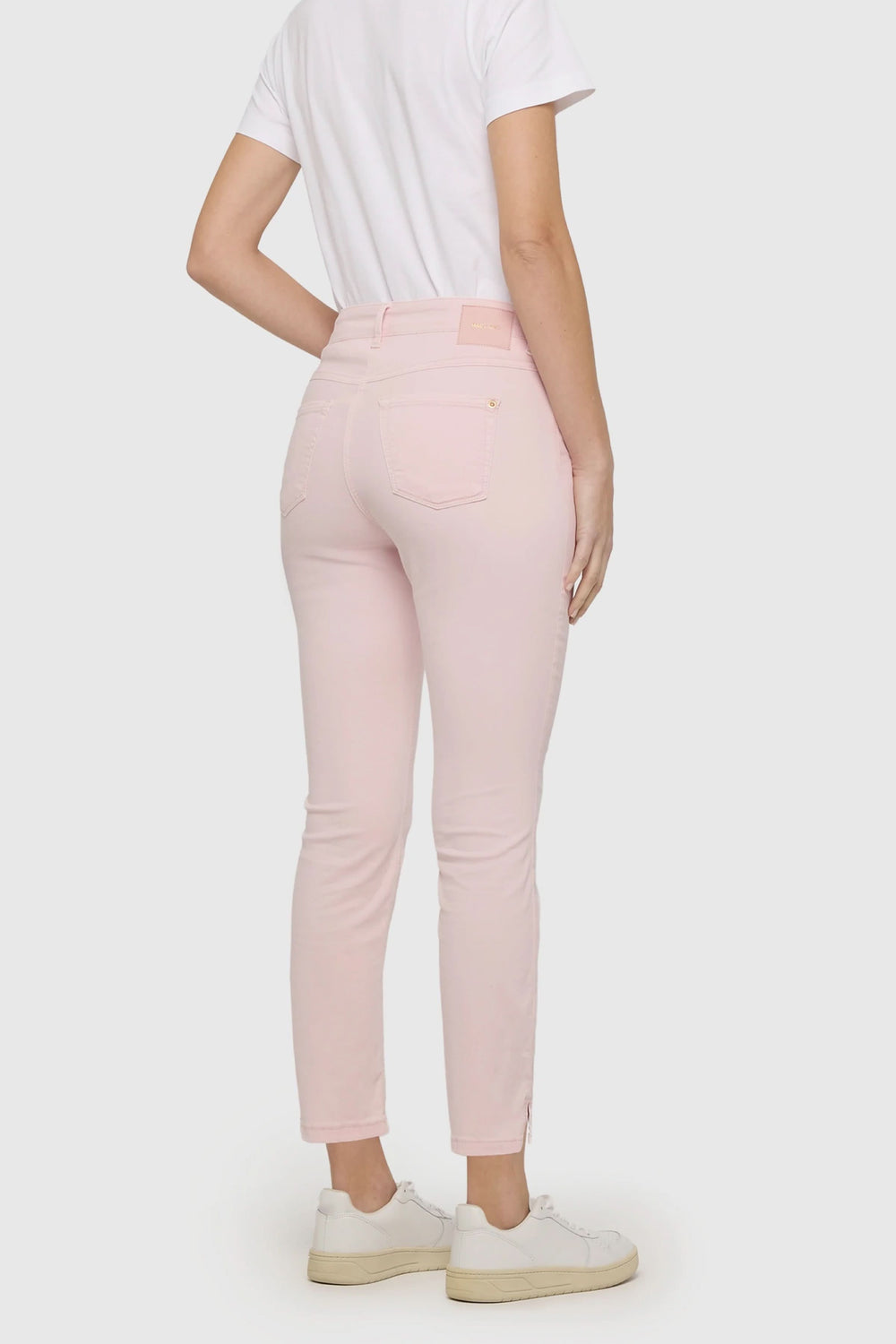 Person wearing Pantalon Dream Summer, pink skinny fit pants, shown from the back, paired with a white t-shirt and sneakers.