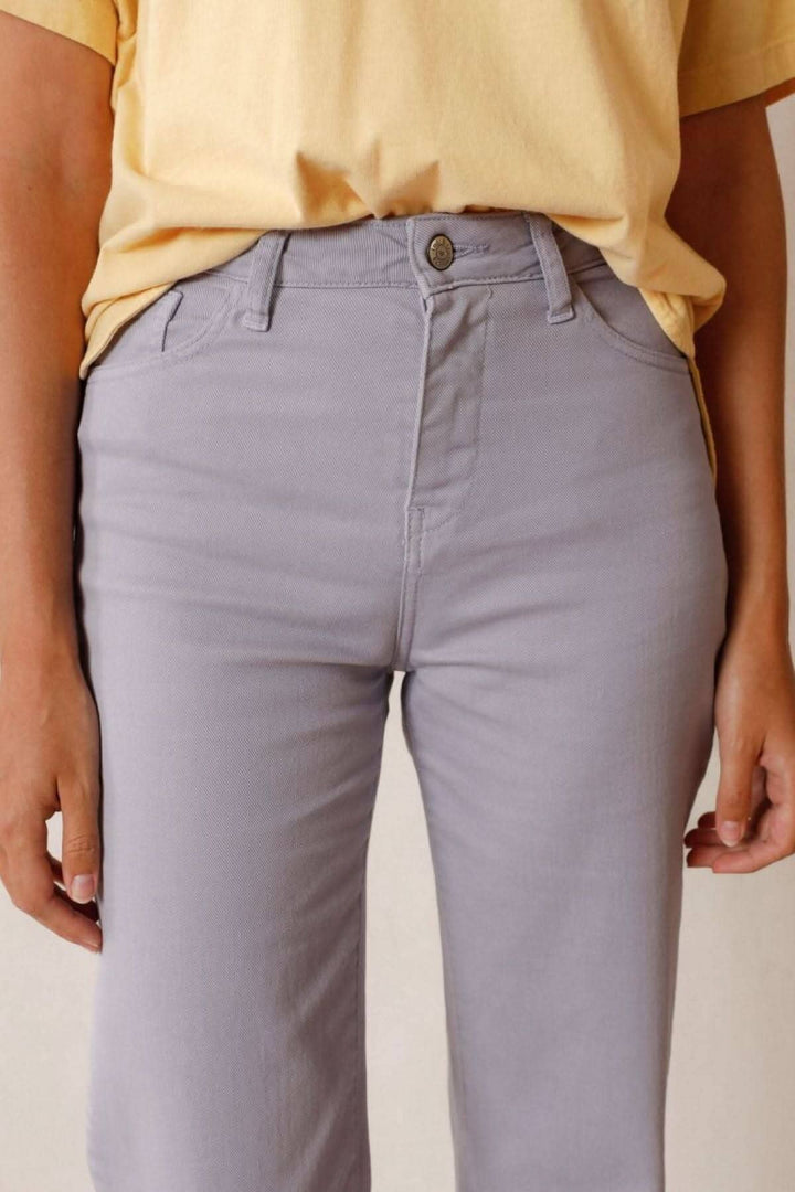 Pantalon Harry en jean court avec ourlet effiloché, taille haute, porté avec un t-shirt jaune.