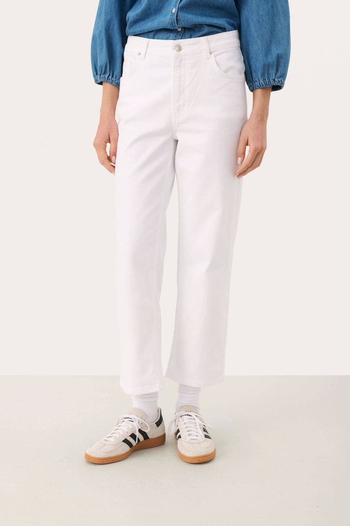Jean cropped blanc évasé avec baskets, look moderne et décontracté, taille mi-haute pour un confort optimal.