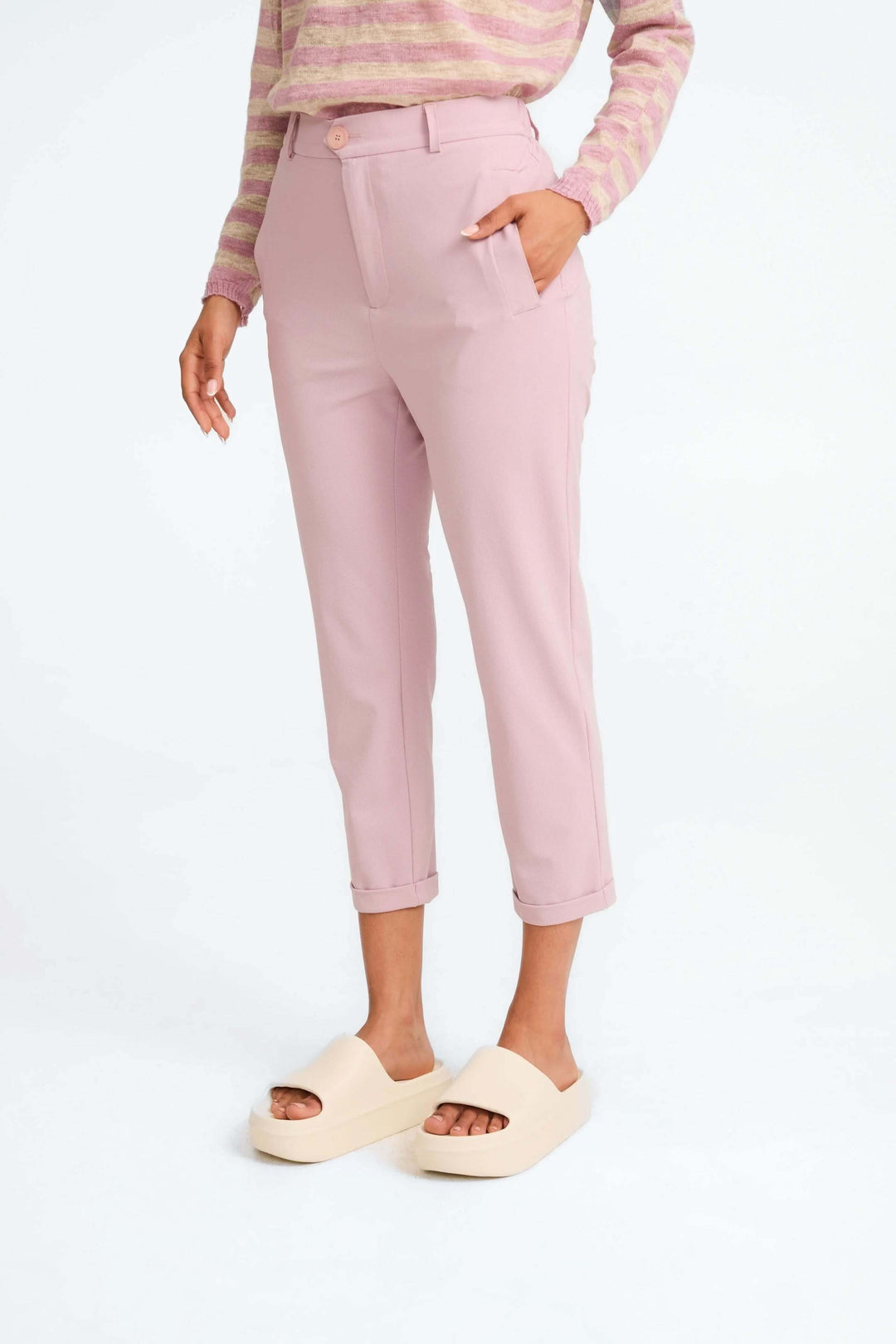 Pantalon Lena rose 7/8e avec taille haute, jambe fuselée et poches, porté avec un chandail rayé.