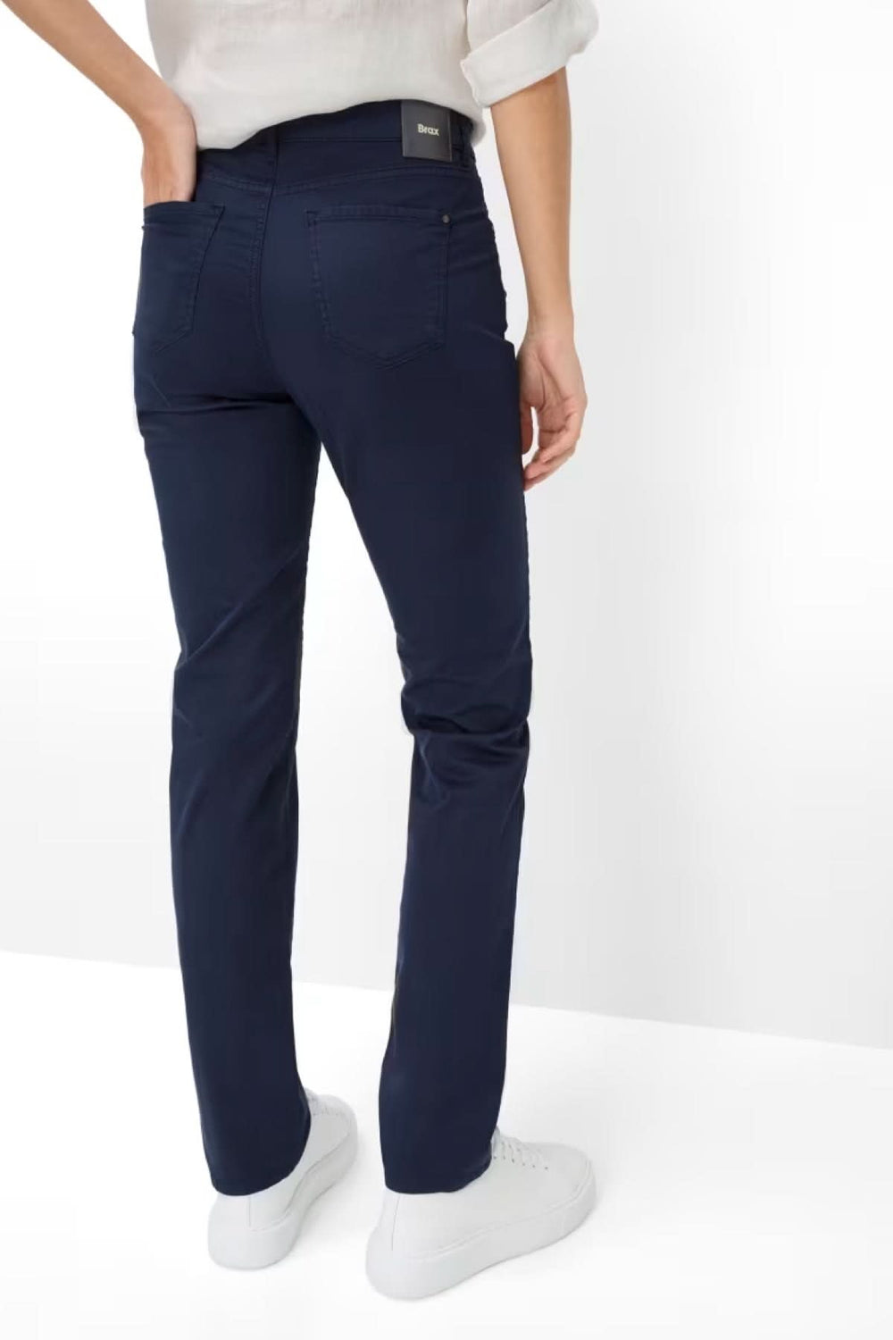 Dos d'une personne portant le Pantalon MARY droit, longueur cheville retroussé, bleu marine, avec des baskets blanches.