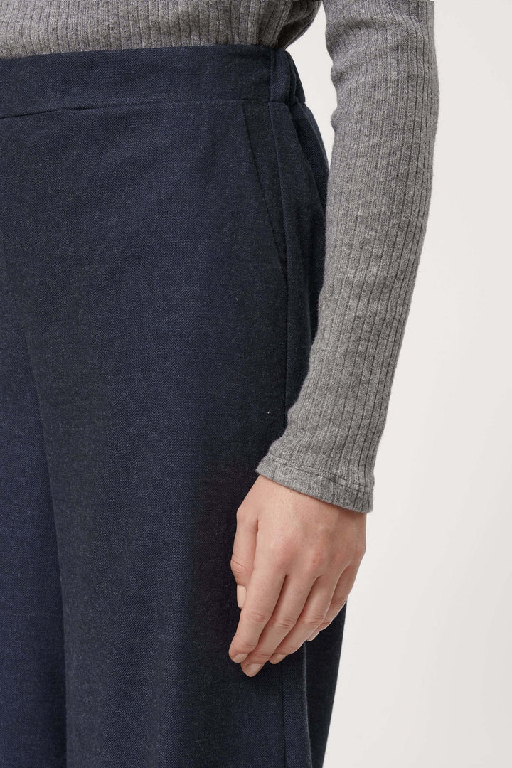Pantalon Sophio bleu marine ample et fluide, style contemporain avec taille élastique et détails élégants, parfait pour look décontracté chic.