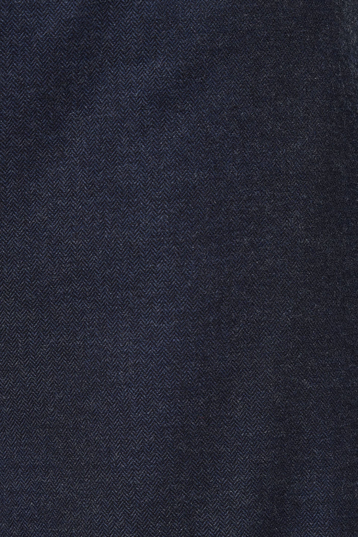 Gros plan sur le tissu du Pantalon Sophio, coton bleu foncé à texture chevron, pour un style urbain et moderne.
