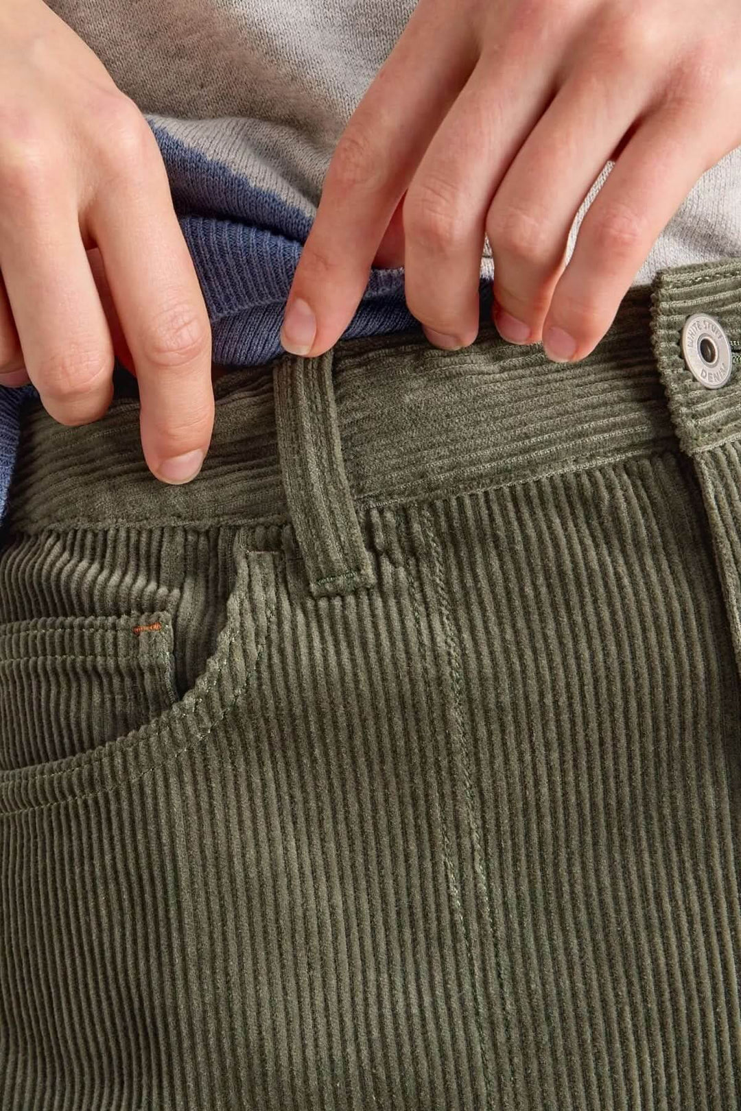 Gros plan sur le Pantalon Tia en velours côtelé texturé, coupe évasée décontractée avec taille haute, portefeuille avec un style moderne.