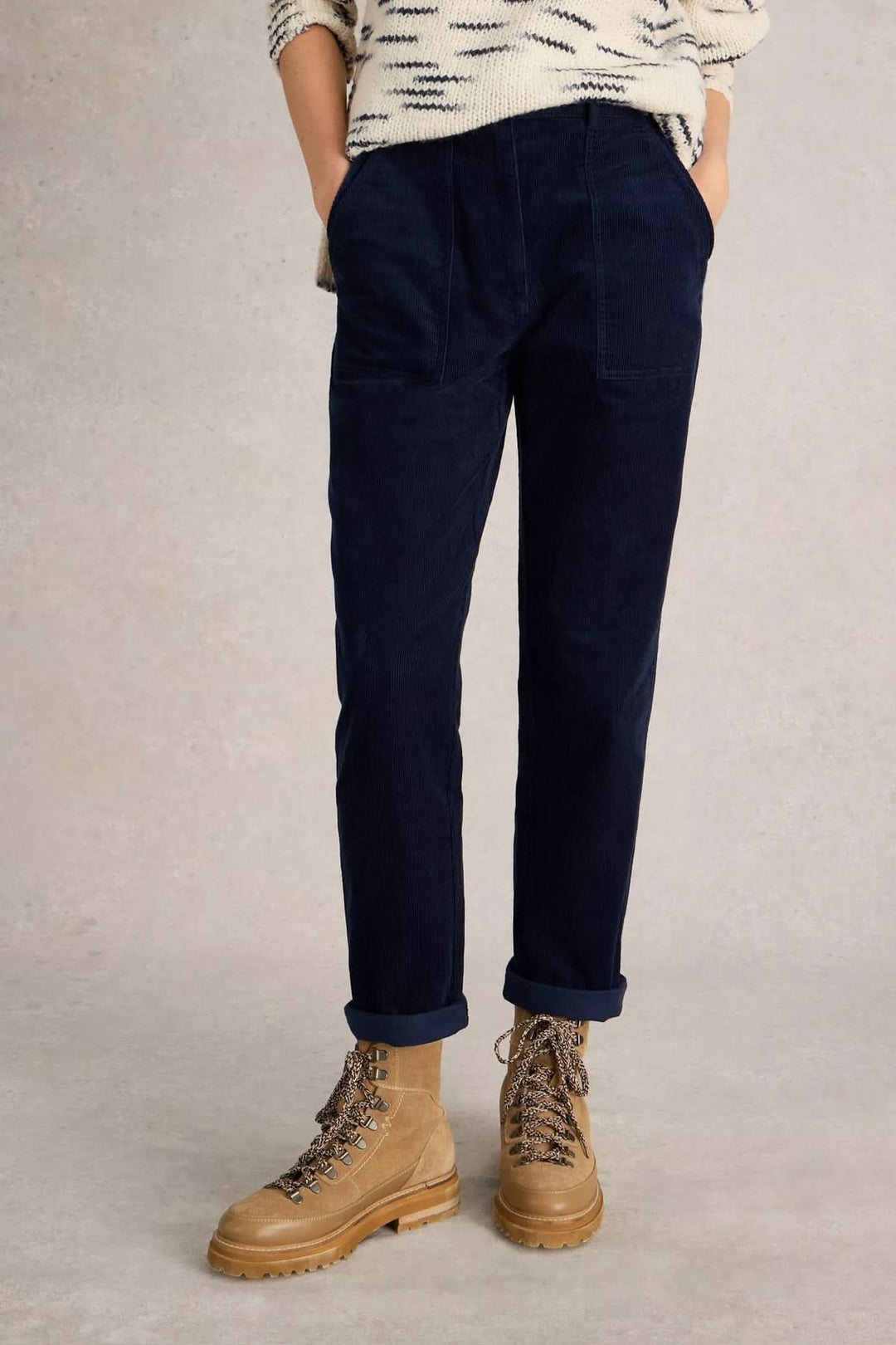 Pantalon Twister en velours côtelé bleu, coupe droite et grandes poches plaquées, porté avec un chandail et des bottes pour un look casual-chic.