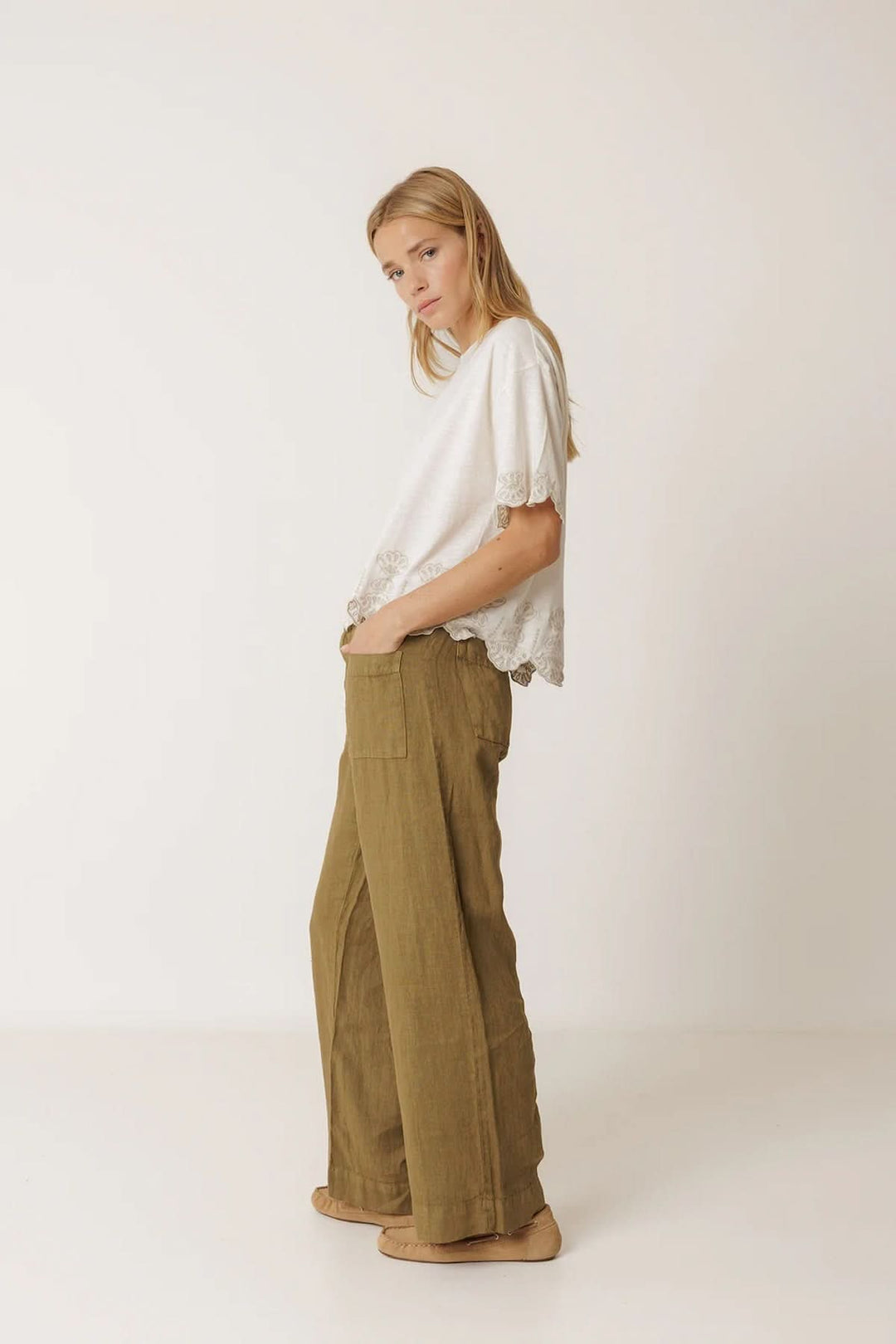 Femme portant un pantalon ample en lin à poches plaquées, style décontracté et moderne.