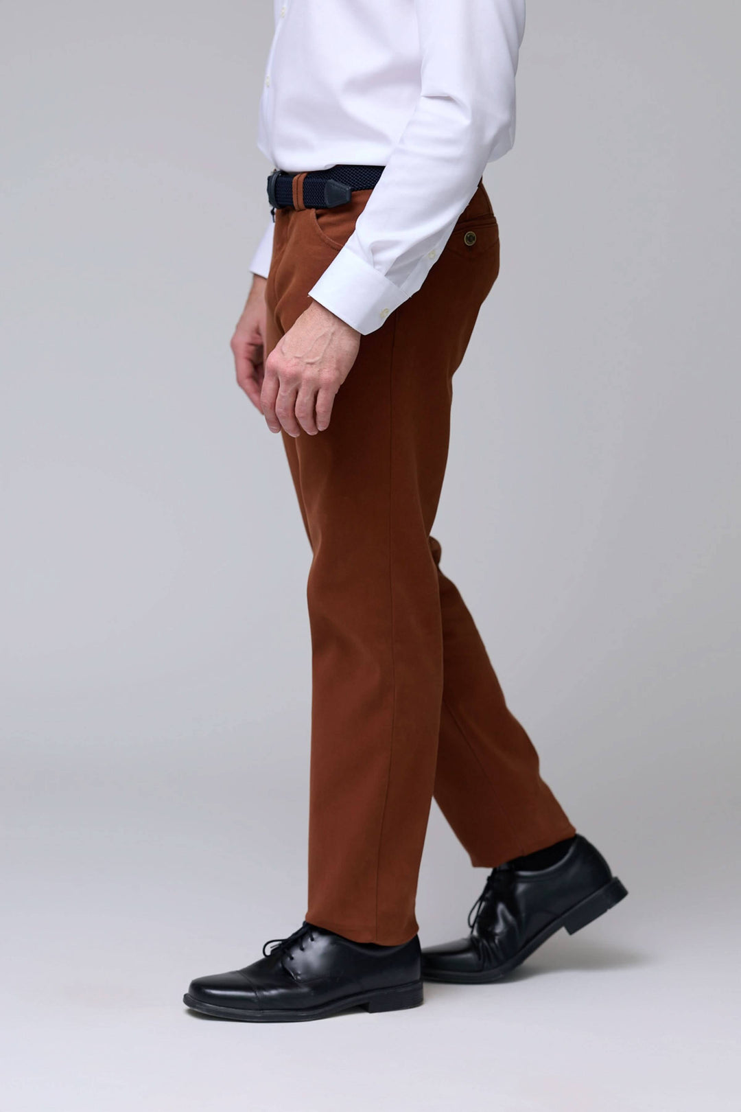 Homme portant un pantalon chino moderne marron avec coupe droite et tissu extensible, idéal pour un style décontracté ou habillé.