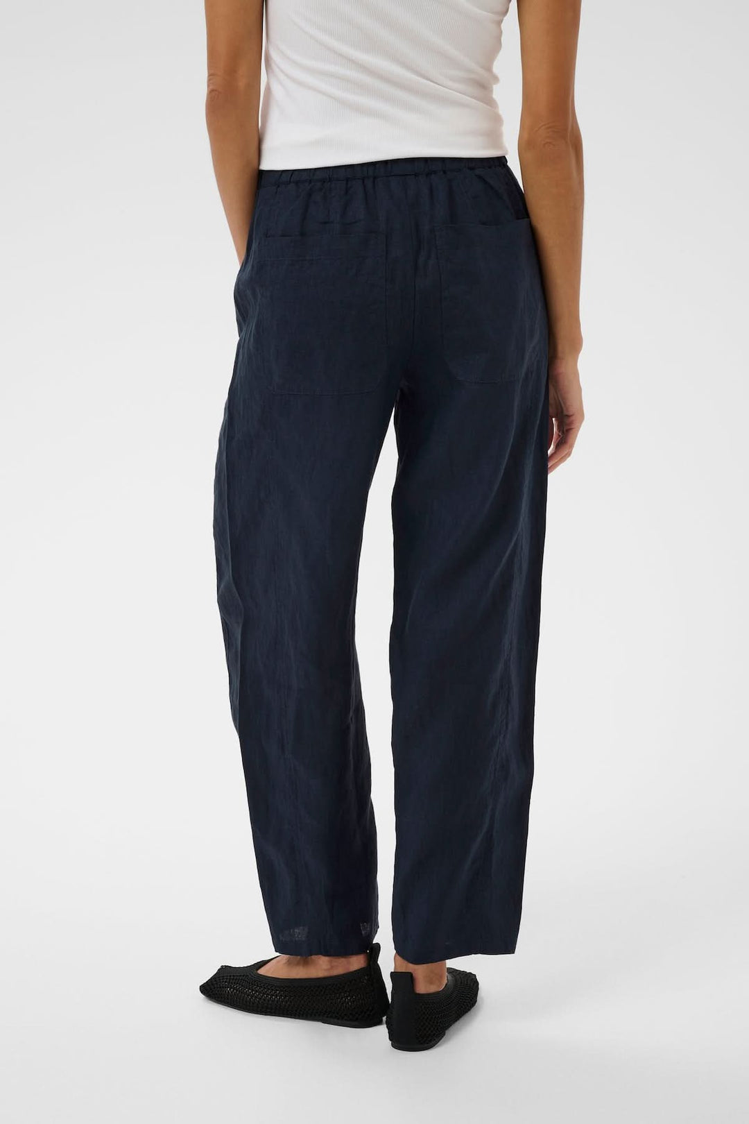 Femme portant le Pantalon en lin Atima bleu sombre, coupe droite, confort quotidien, tissu naturel.