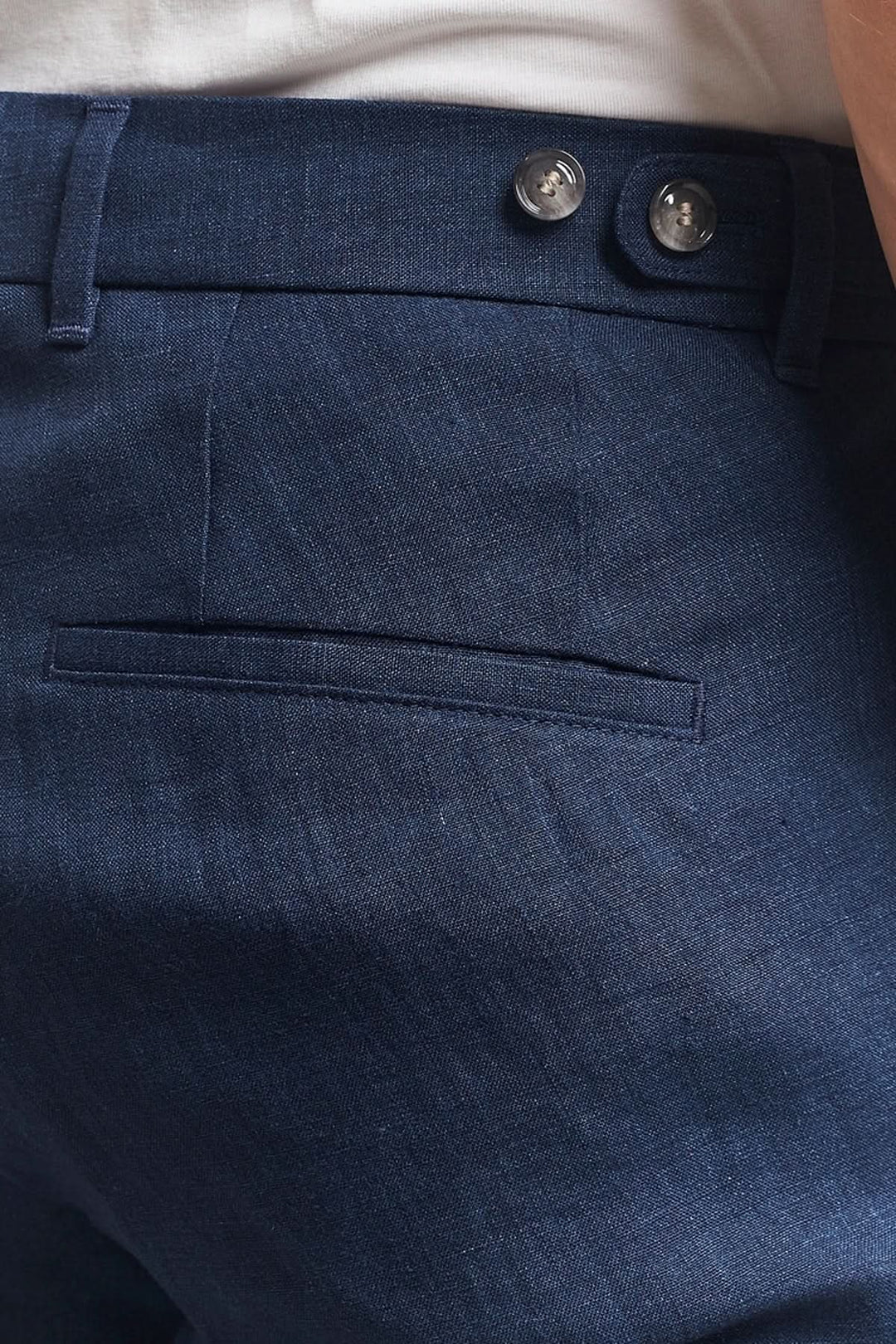 Pantalon en lin bleu marine avec fermeture par agrafe et poches latérales, offrant élégance et confort.
