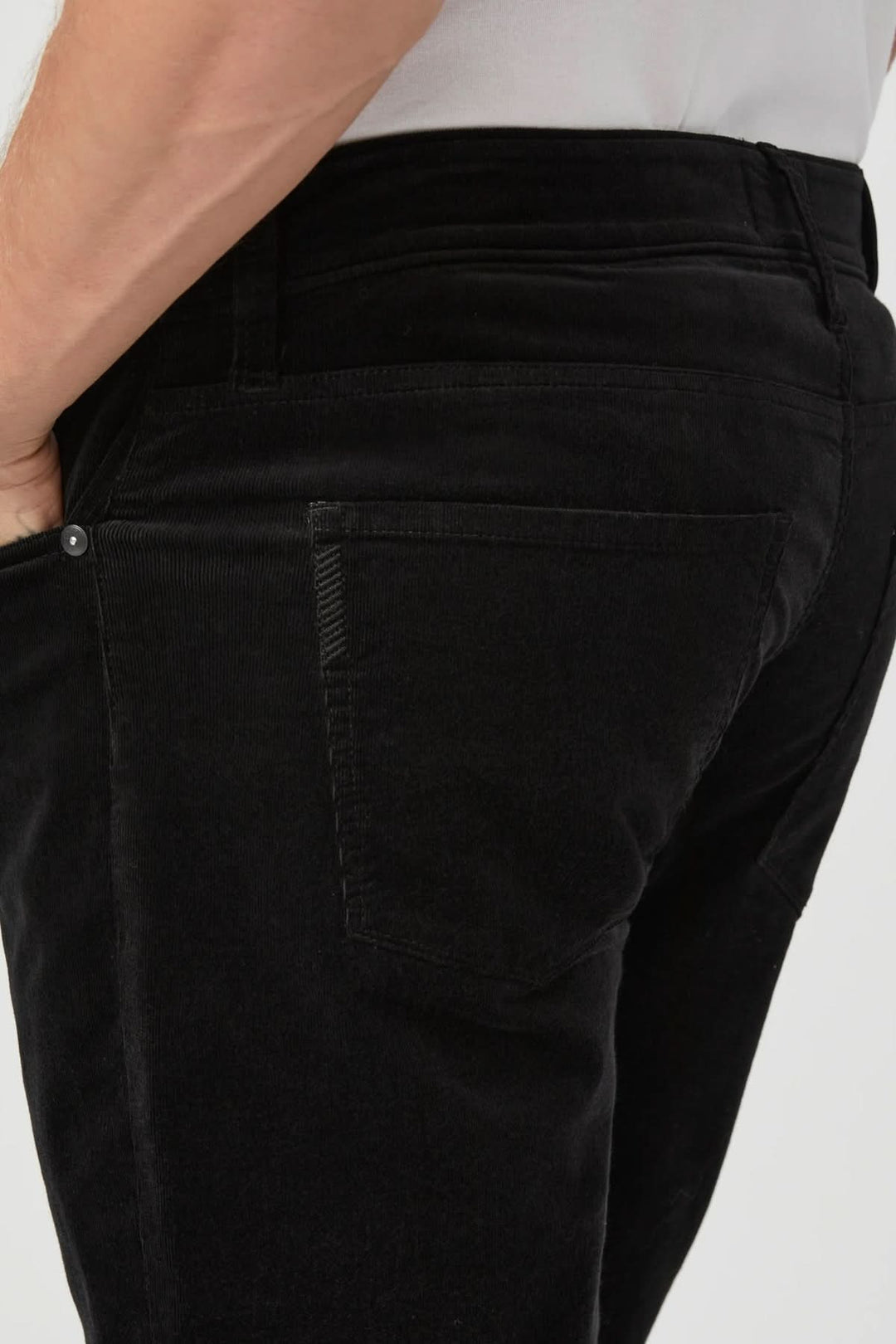Pantalon en micro corduroy noir, coupe ajustée pour élégance moderne et polyvalente, en micro-velours côtelé doux et extensible.