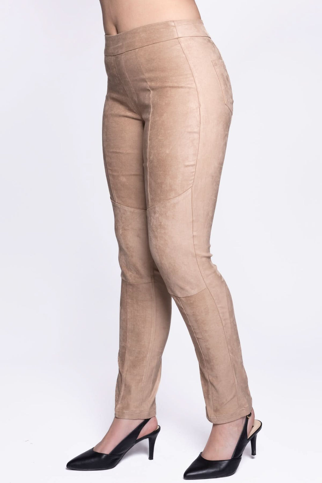 Pantalon en velours extensible, coupe ajustée, couleur beige, avec poches et taille à enfiler, porté avec des escarpins.