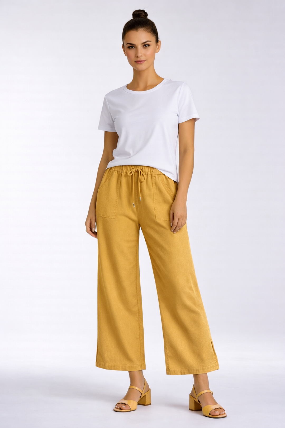 Femme portant un pantalon fluide taille élastique à cordon en jaune, offrant une silhouette décontractée et élégante.