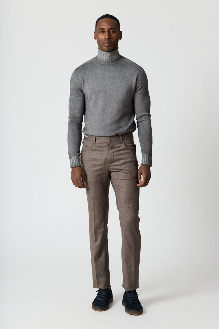 Homme portant un pantalon habillé 5 poches en laine Corneliani avec un pull gris.