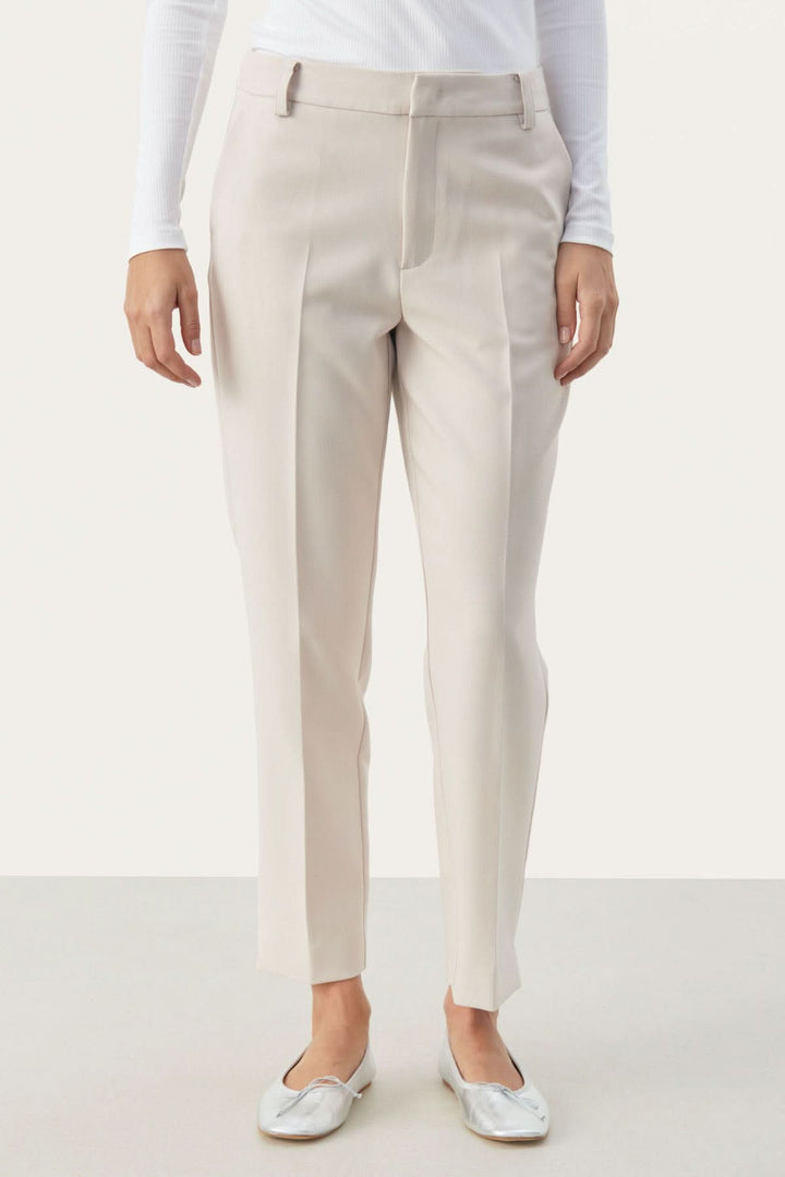 Pantalon habillé Urbana, coupe fuseau élégante, tissu léger, poches pratiques, finition raffinée avec fente à la cheville.