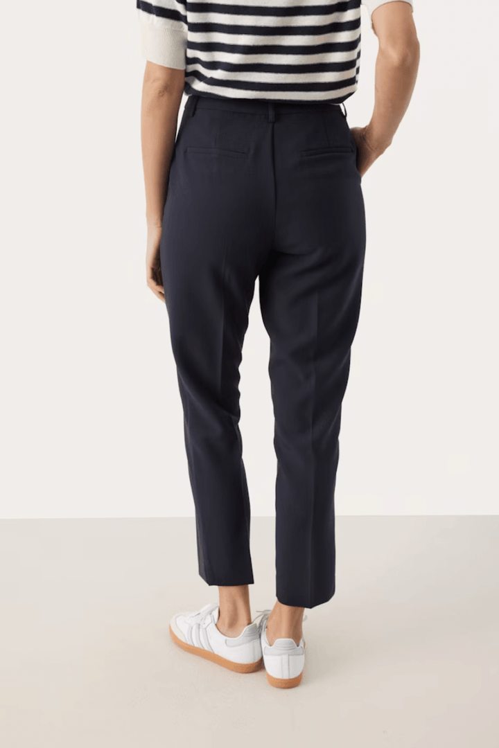 Pantalon habillé Urbana, coupe fuseau élégante, vue arrière, porté avec un top rayé et des baskets blanches.