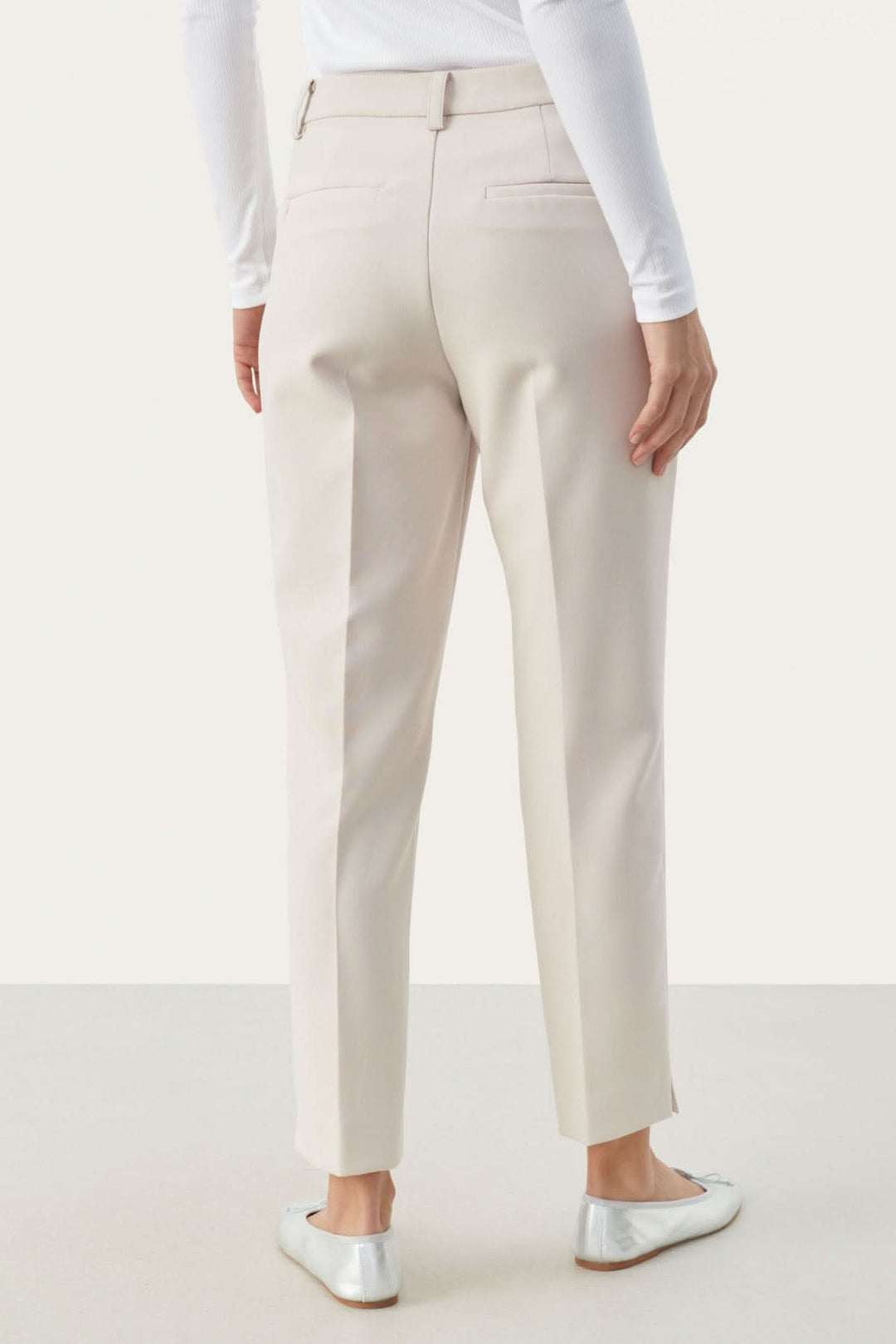 Vue arrière du pantalon habillé Urbana, coupe fuseau élégante, en tissu léger, avec poches et petite fente à la cheville.