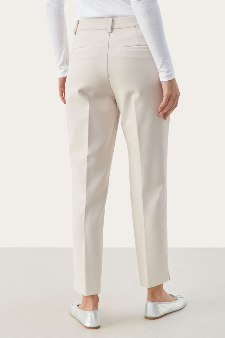 Vue arrière du pantalon habillé Urbana, coupe fuseau élégante, en tissu léger, avec poches et petite fente à la cheville.