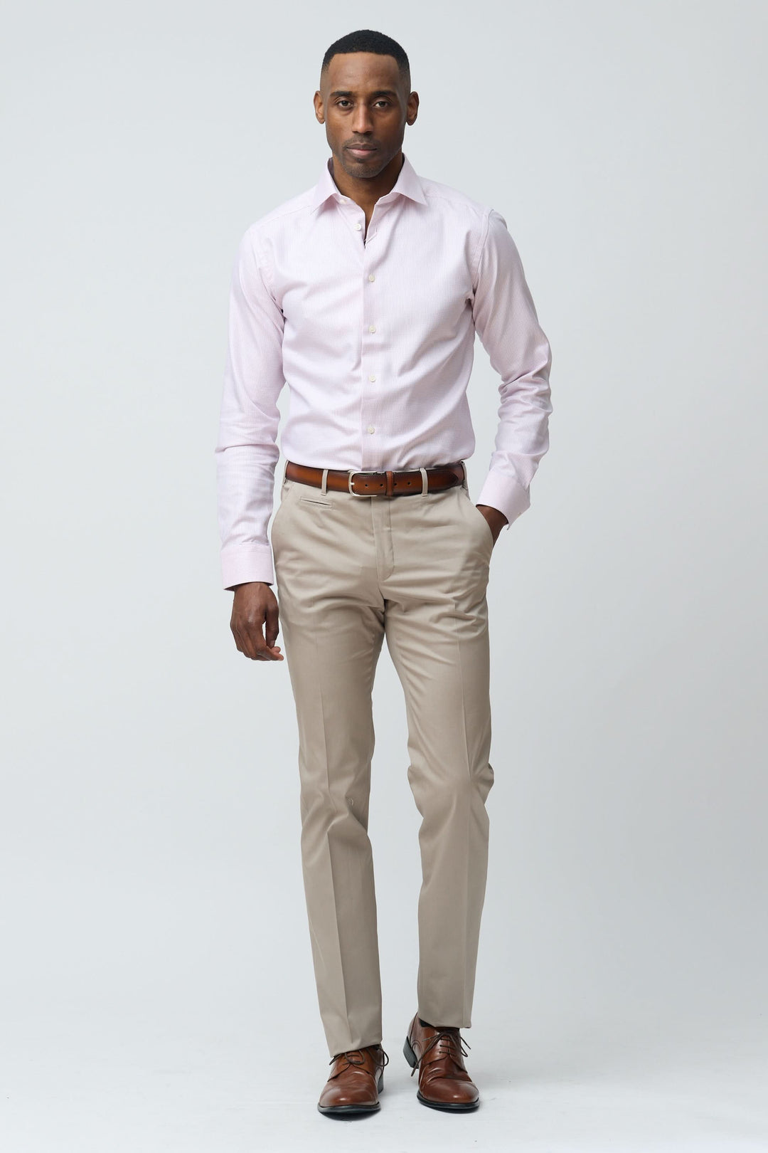 Homme portant un pantalon habillé coupe ajustée avec une chemise rose, look élégant et professionnel.