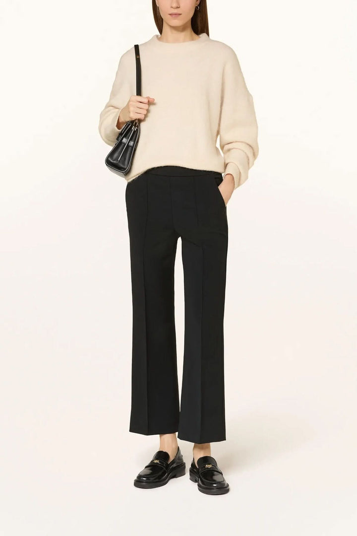 Pantalon habillé coupe droite à plis marqués avec chandail pour un look élégant et confortable.