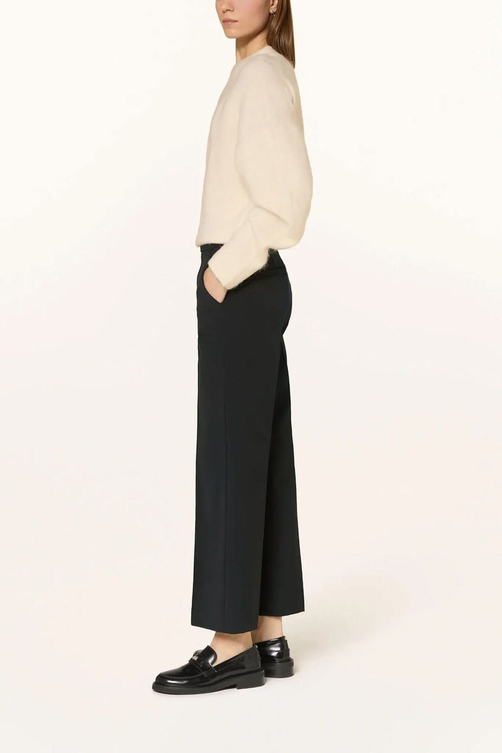 Pantalon habillé coupe droite à plis marqués en noir, porté avec élégance, montrant la coupe droite et les plis marqués.