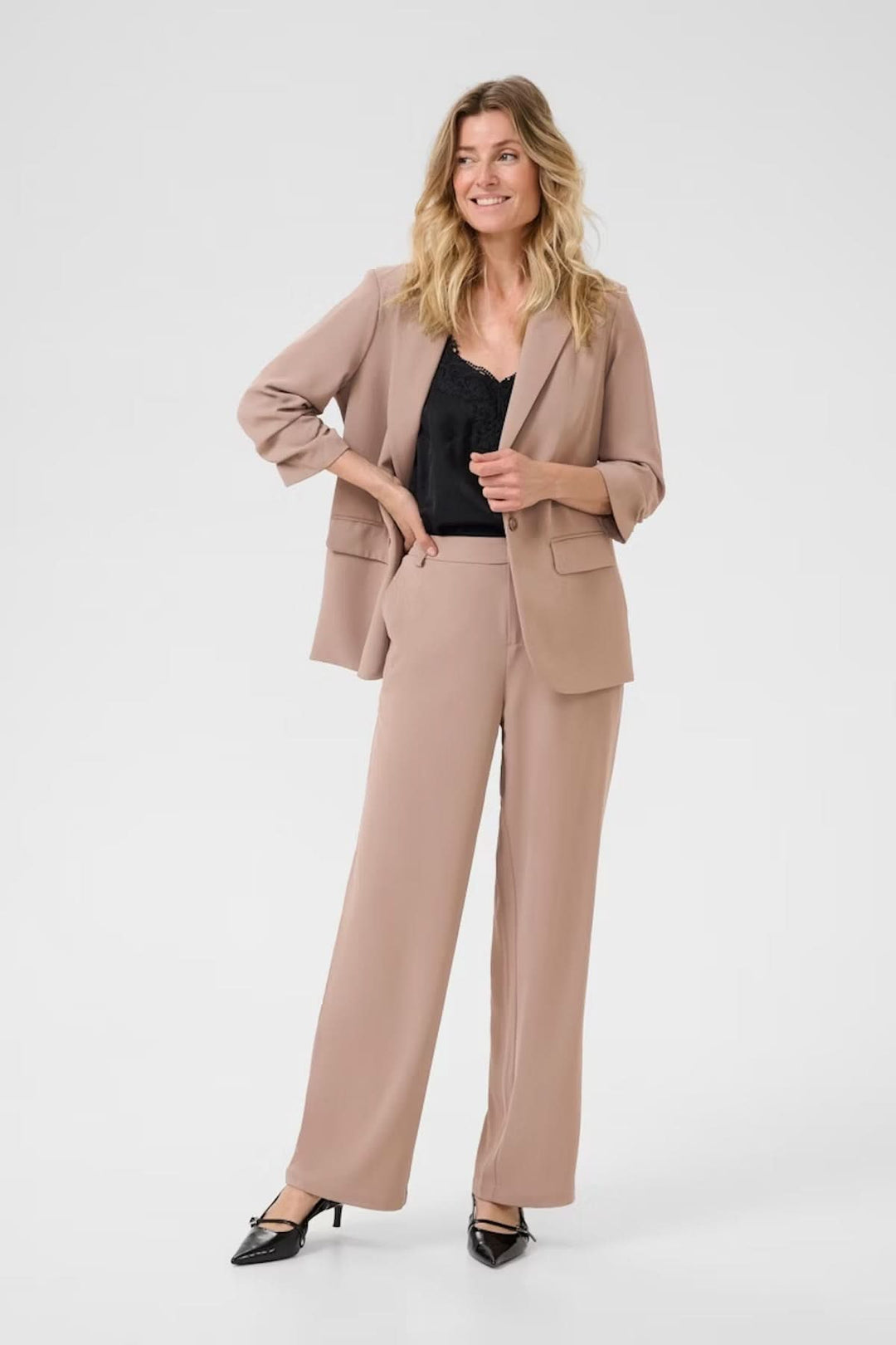 Femme portant un pantalon à jambe large avec veste, offrant une coupe fluide et élégante, idéal pour un look professionnel.