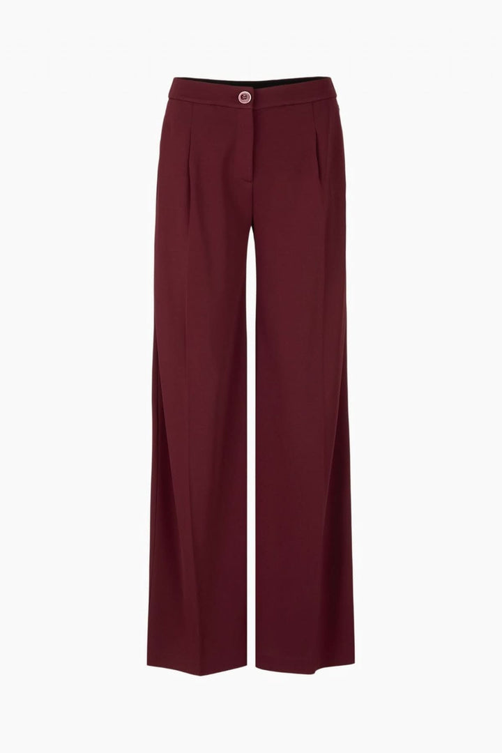 Pantalon jambes larges élégant en tissu fluide avec taille haute et plis marqués, couleur bordeaux, parfait pour un style raffiné.