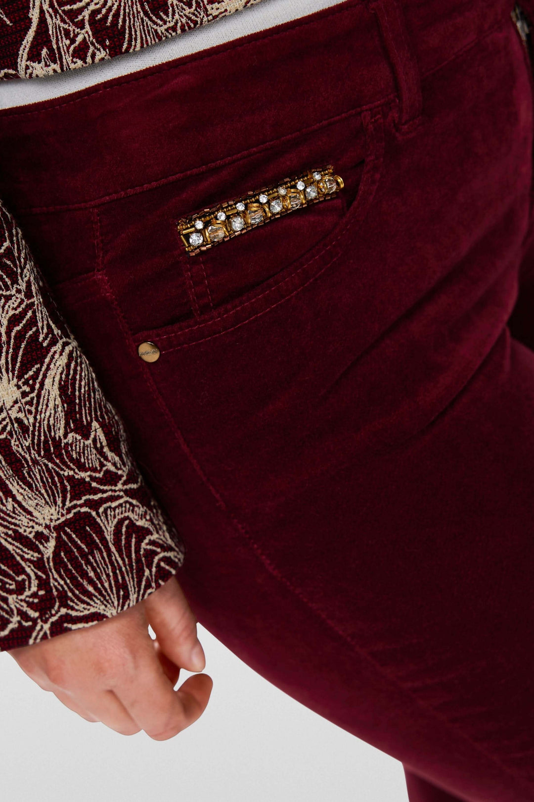Pantalon taille basse en velours rouge avec détails satinés et coupe ajustée pour une silhouette élégante.