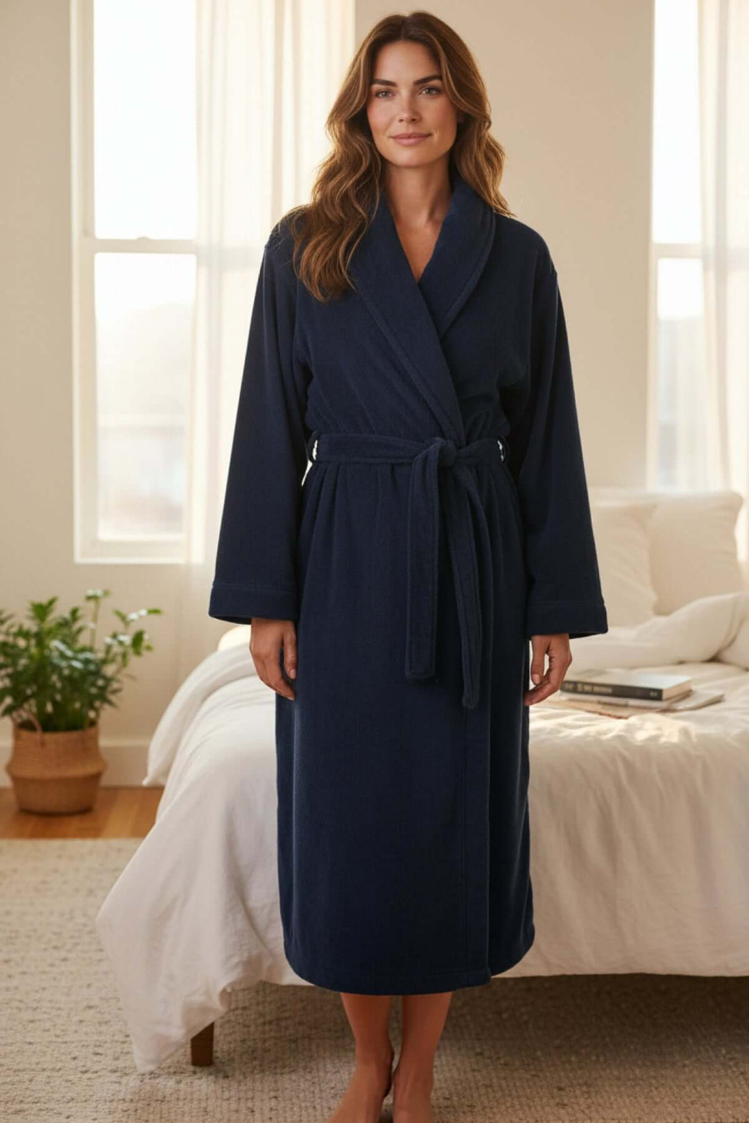 Femme portant un peignoir long en micro-polar bleu foncé, noué à la taille, parfait pour les moments de détente à la maison.