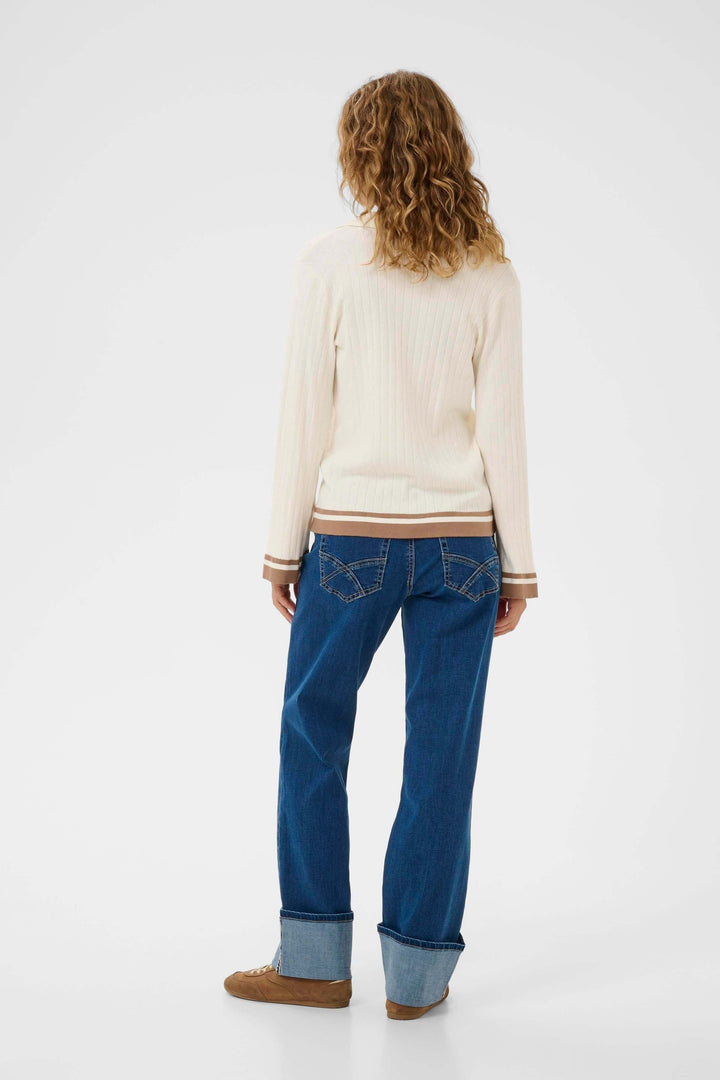 Vue arrière du Polo Villea blanc avec détails contrastants, style raffiné et féminin, porté avec un jean bleu. Décris moi le produit en français.