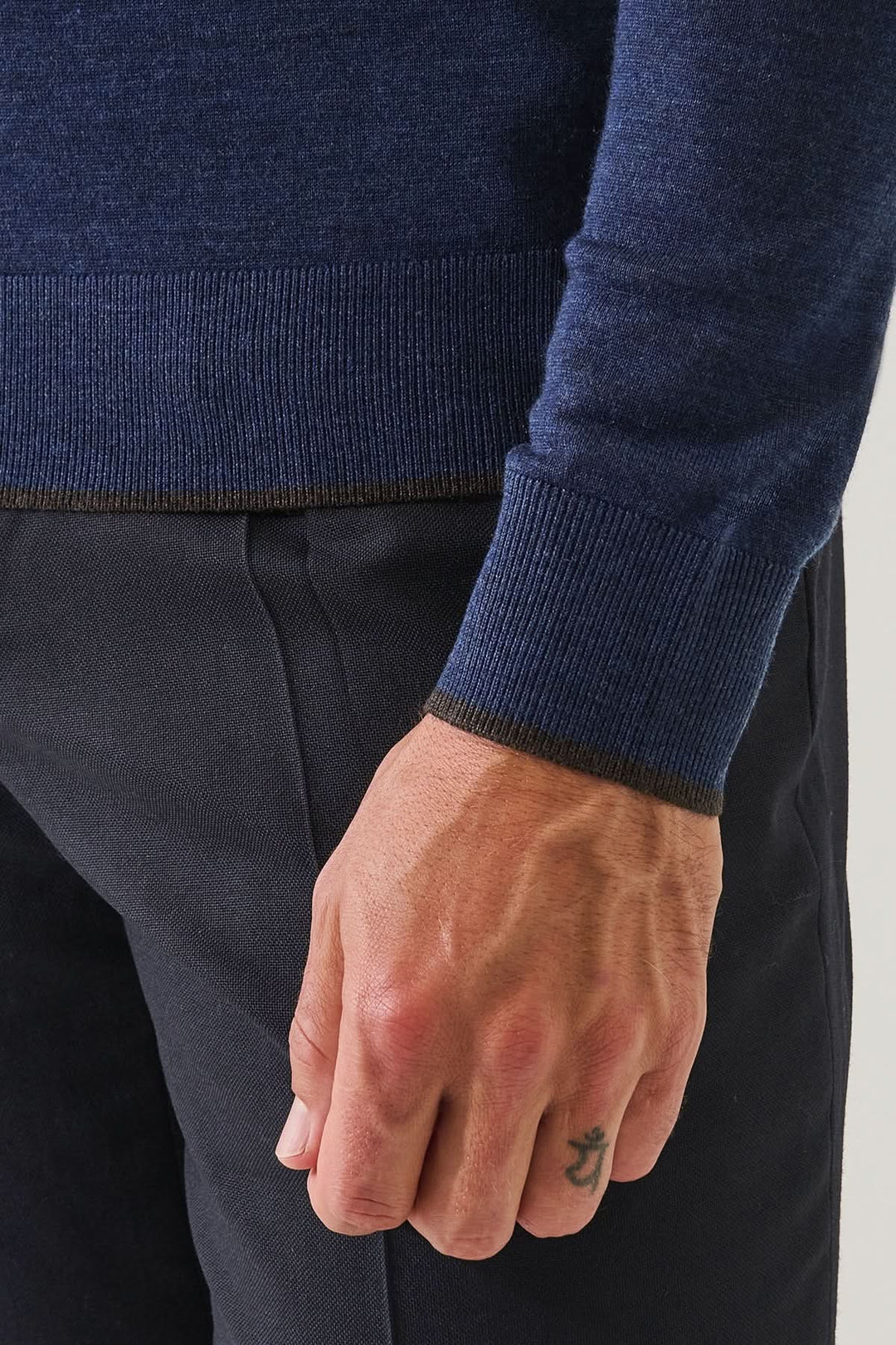 Modèle portant un polo boutonné en laine mérinos extra-fine avec maille fine et élégan