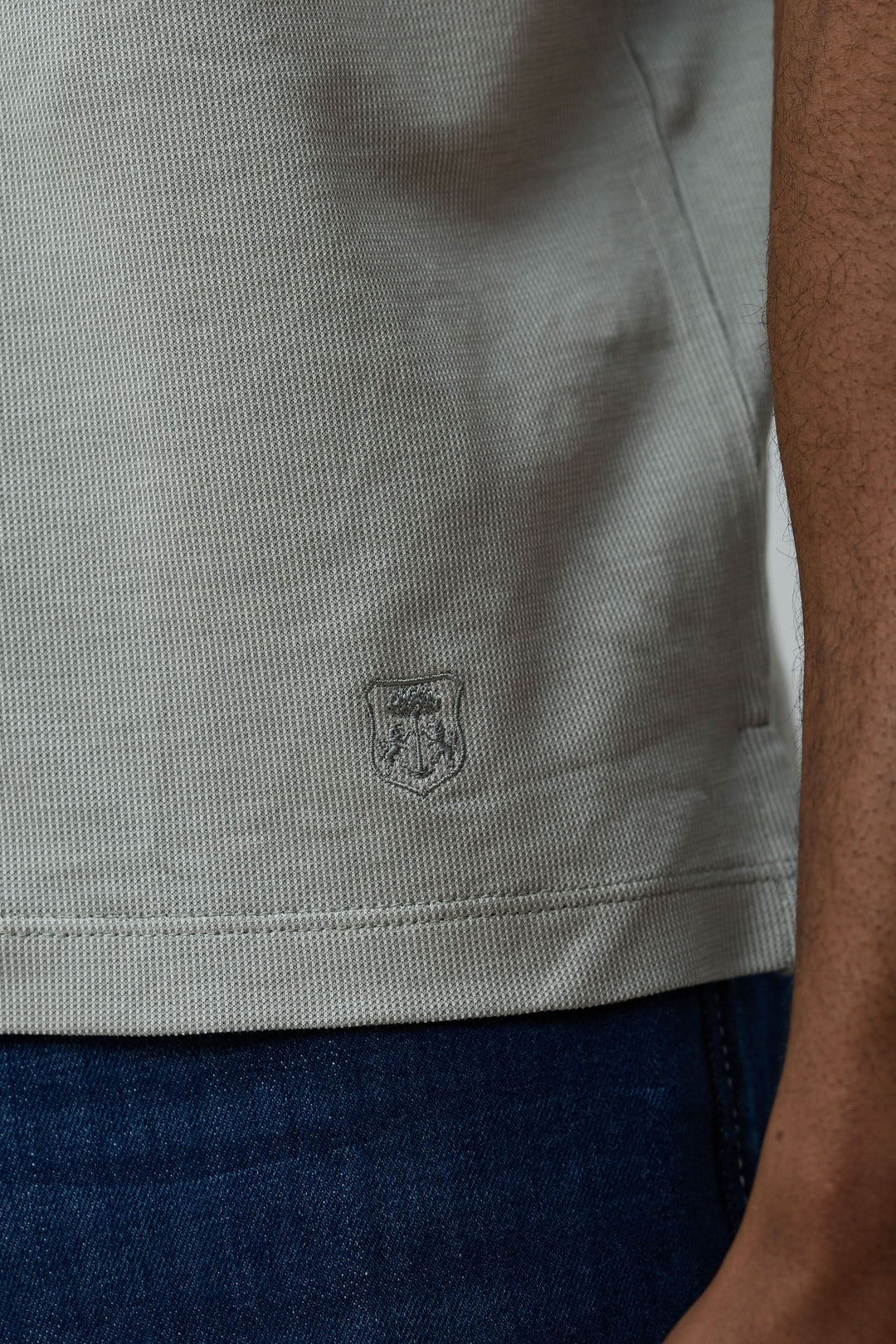 Détail de la maille texturée du Polo en coton Corneliani avec jeans, élégant et confortable pour un look décontracté chic.