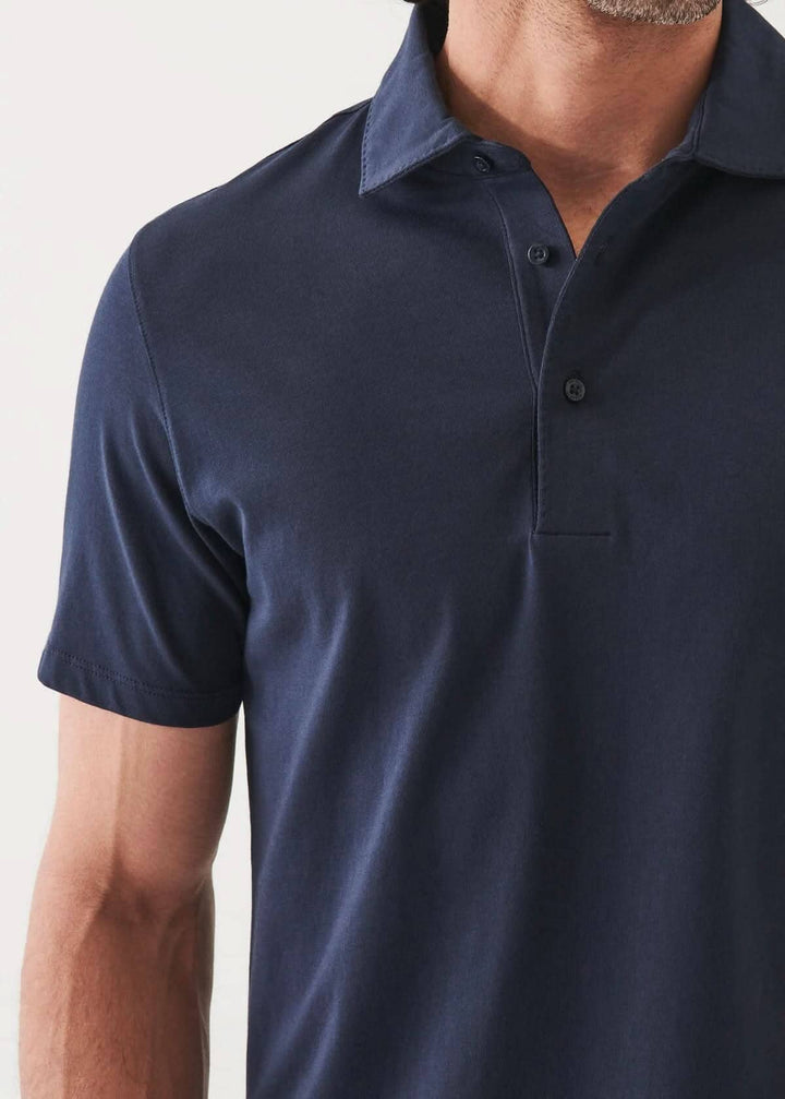 Polo à manches courtes de couleur bleu marine, avec col classique et patte de boutonnage à deux boutons.