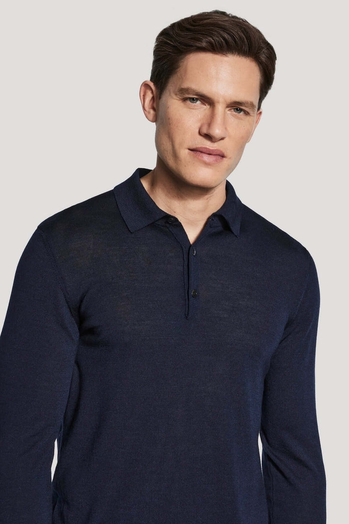 Homme portant un polo manches longues en laine mérinos et soie de couleur bleue, élégant et moderne, ajusté pour un confort optimal.