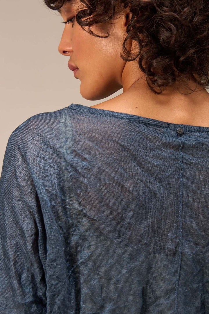 Pull clair avec texture froissée, manches longues, porté de dos, parfait pour un look décontracté et naturel.