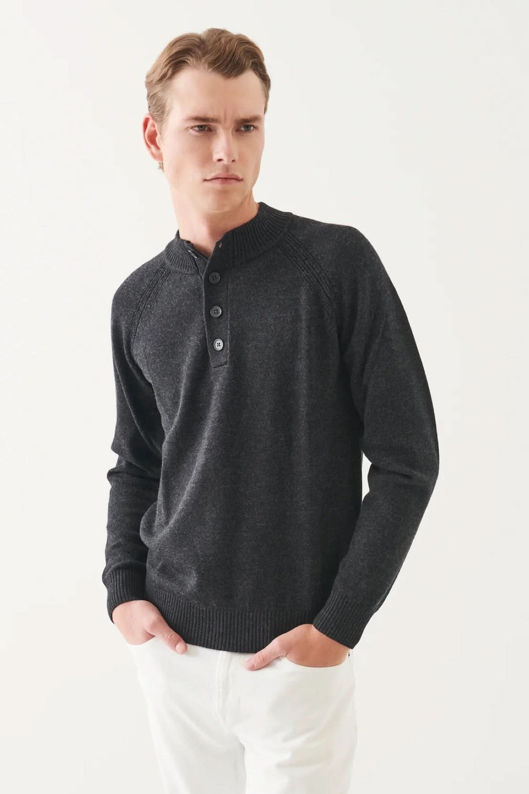 Pull-over en laine mérinos avec col boutonné, style élégant et confortable, manches raglan, couleur foncée.