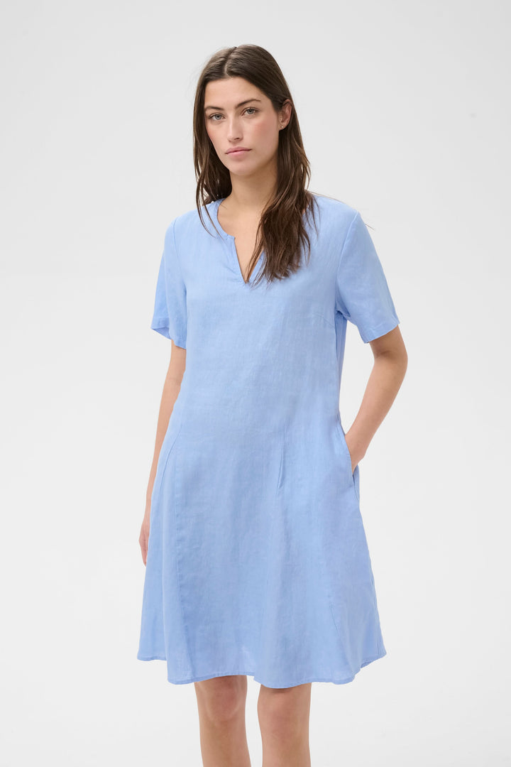 Robe Aminasa bleu à encolure en V, coupe fluide évasée, manches courtes et poches latérales, pour une allure naturelle et élégante.