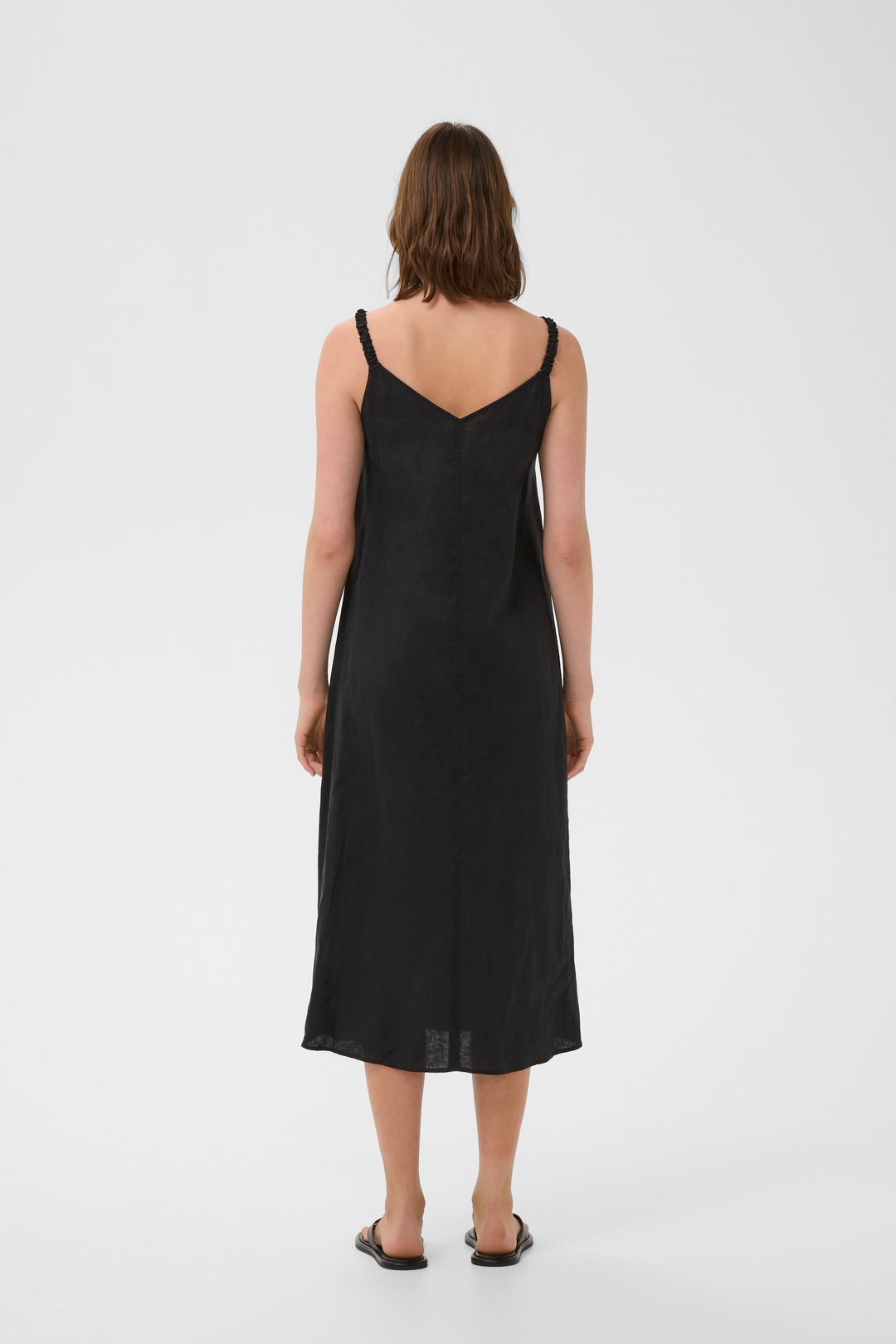 Vue arrière de la Robe Elinor midi fluide à bretelles fines en lin noir, coupe ample et encolure en V.