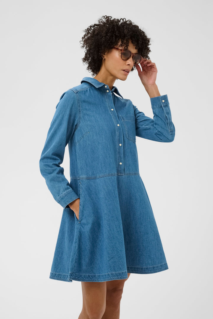 Robe chemise Augustine en denim avec coupe évasée, manches longues et poche poitrine, parfaite pour un style décontracté et polyvalent.
