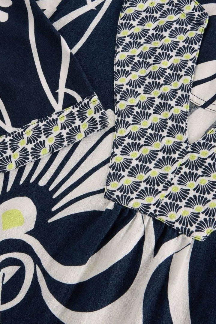 Détail du tissu en lin cendré avec motifs graphiques et col en V, présentant une coupe ample.