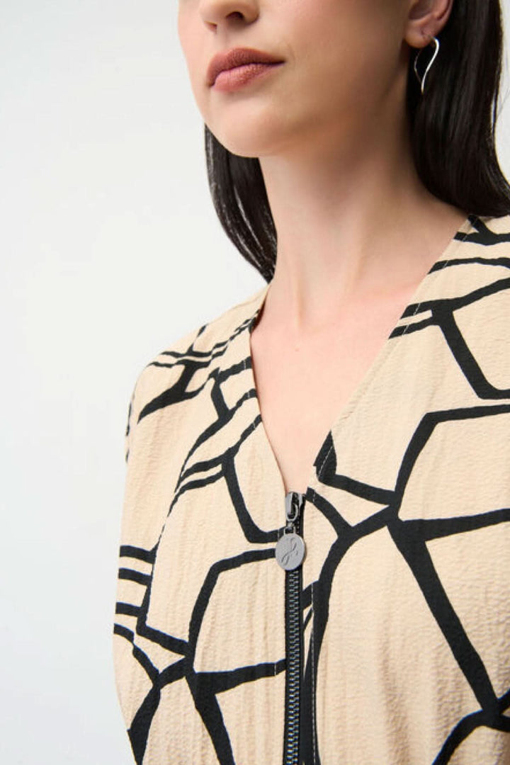 Robe imprimée à taille marquée avec imprimé graphique audacieux en gros plan, montrant le corsage fluide et le col en V.