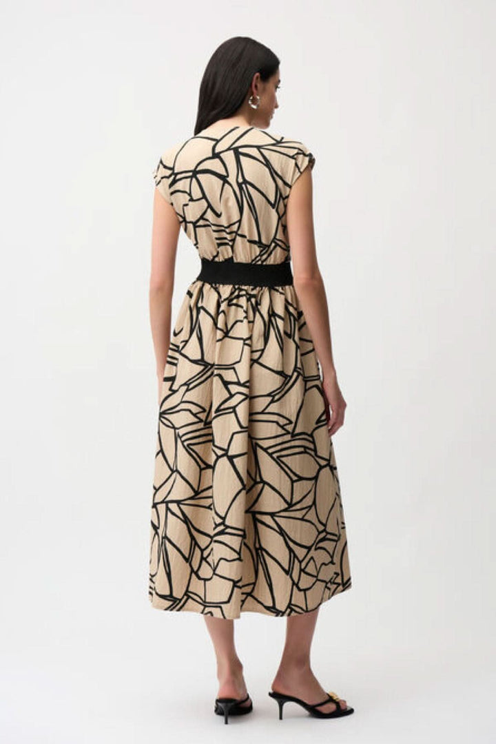 Robe imprimée à taille marquée vue de dos, avec imprimé graphique et bande contrastante, pour une silhouette féminine et moderne.