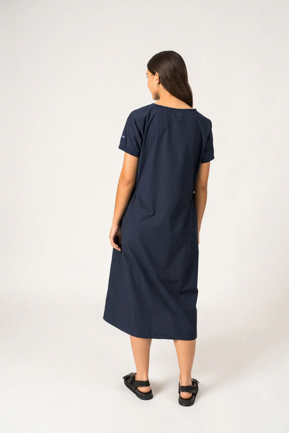 Femme portant la robe midi Morgane avec encolure ronde et manches courtes, vue de dos. Robe élégante et confortable idéale pour toute occasion.