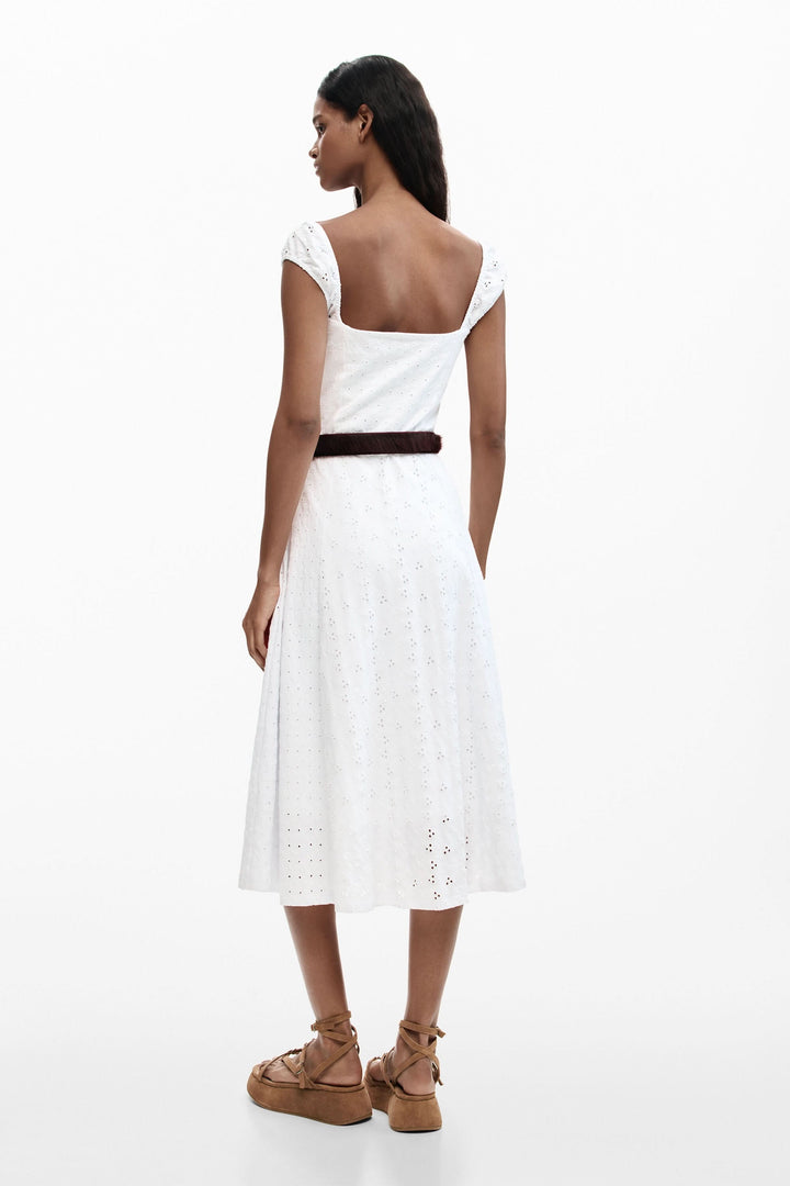 Femme portant une robe midi brodée en broderie anglaise avec une encolure cœur et bretelles larges, vue de dos.