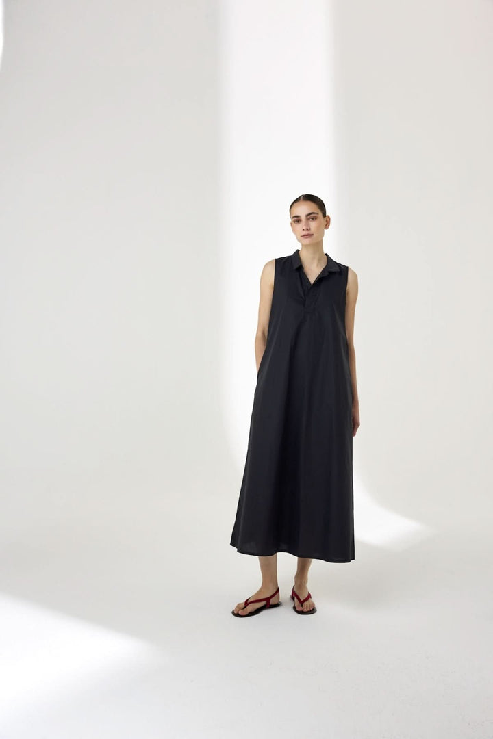 Robe midi sans manches à col chemise élégante, silhouette fluide, parfaite pour une allure moderne et estivale, col chemise visible.