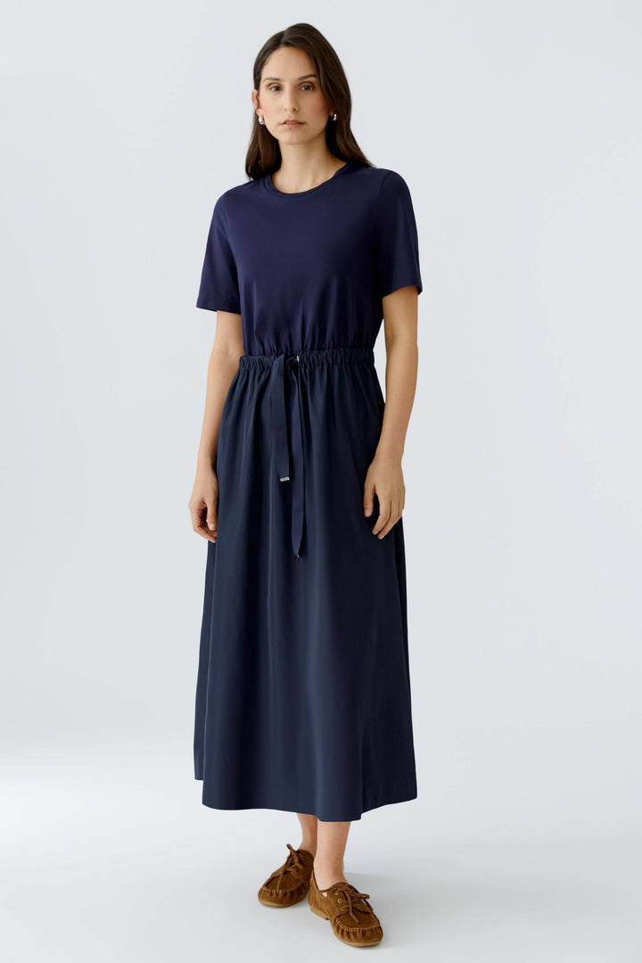 Robe midi à taille ajustable en bleu, style minimaliste avec manches courtes et jupe fluide, parfaite pour un look élégant sans effort.
