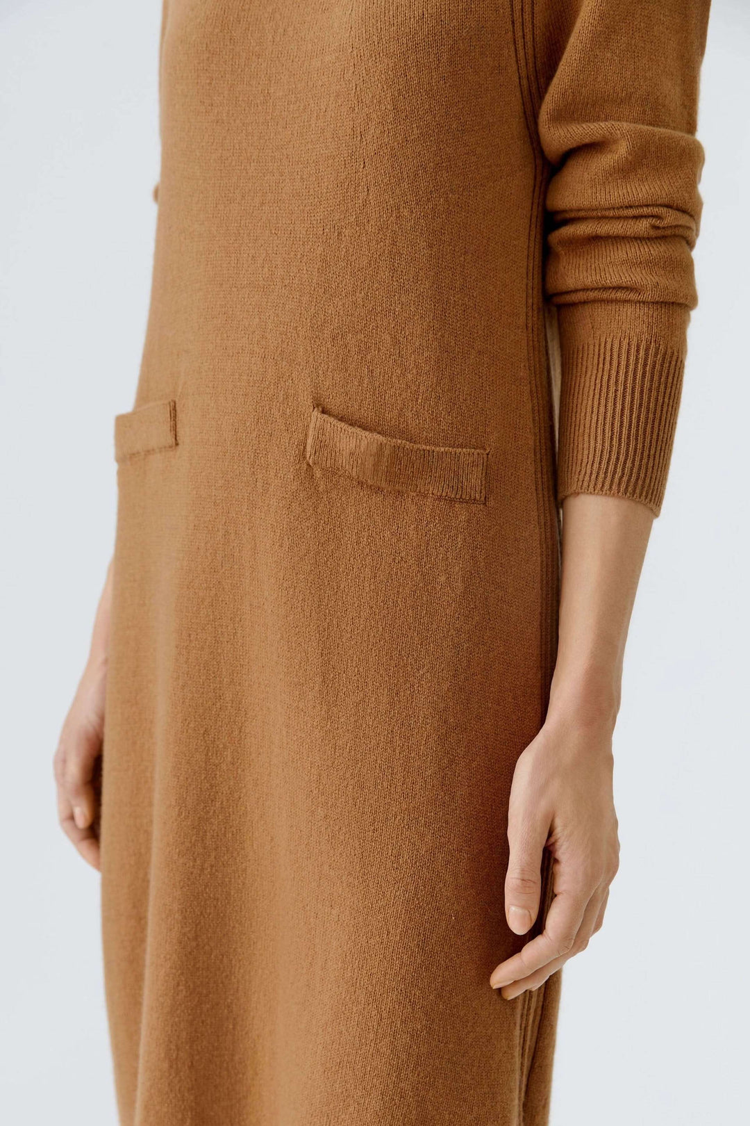 Robe tricotée à manches longues et poches plaquées pour une tenue automnale élégante.