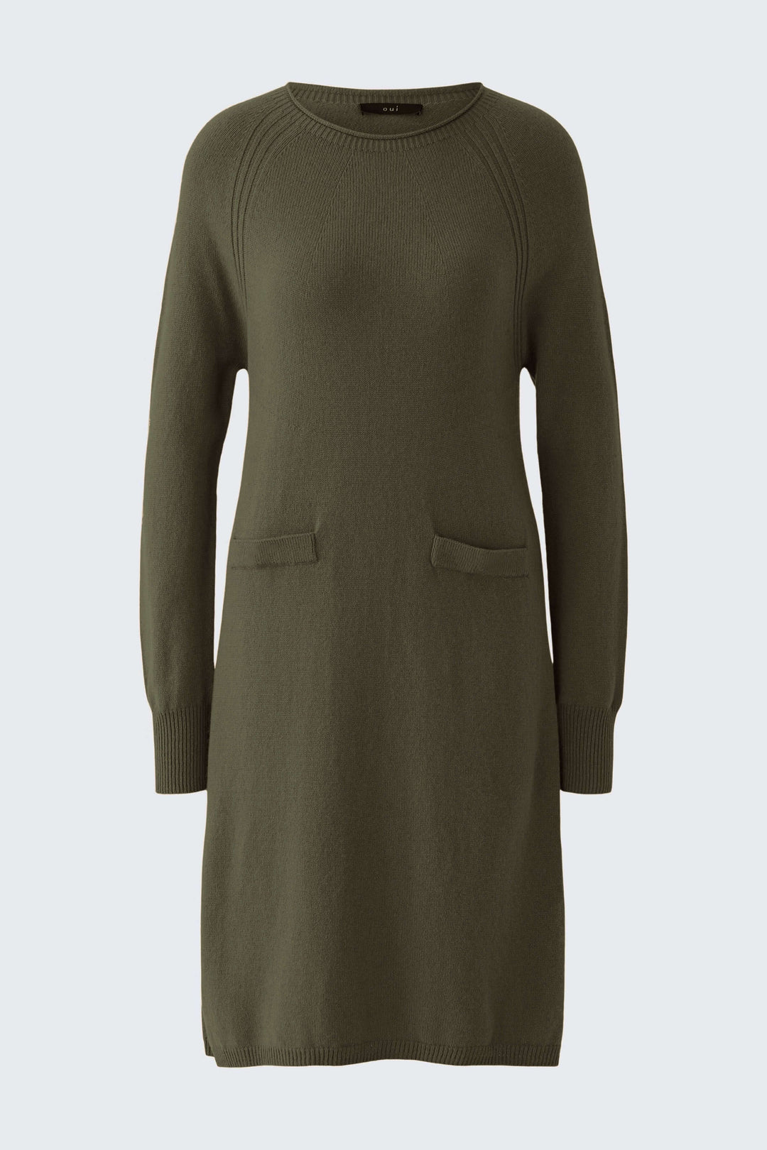 Robe tricotée à manches longues et poches plaquées verte sur fond clair, avec une coupe décontractée et finitions côtelées.